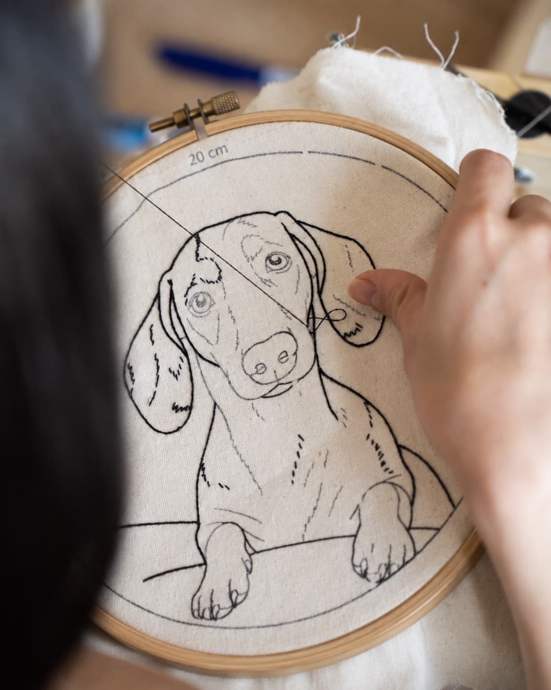 Bastidor em execução com o retrato bordado de um cão salsicha